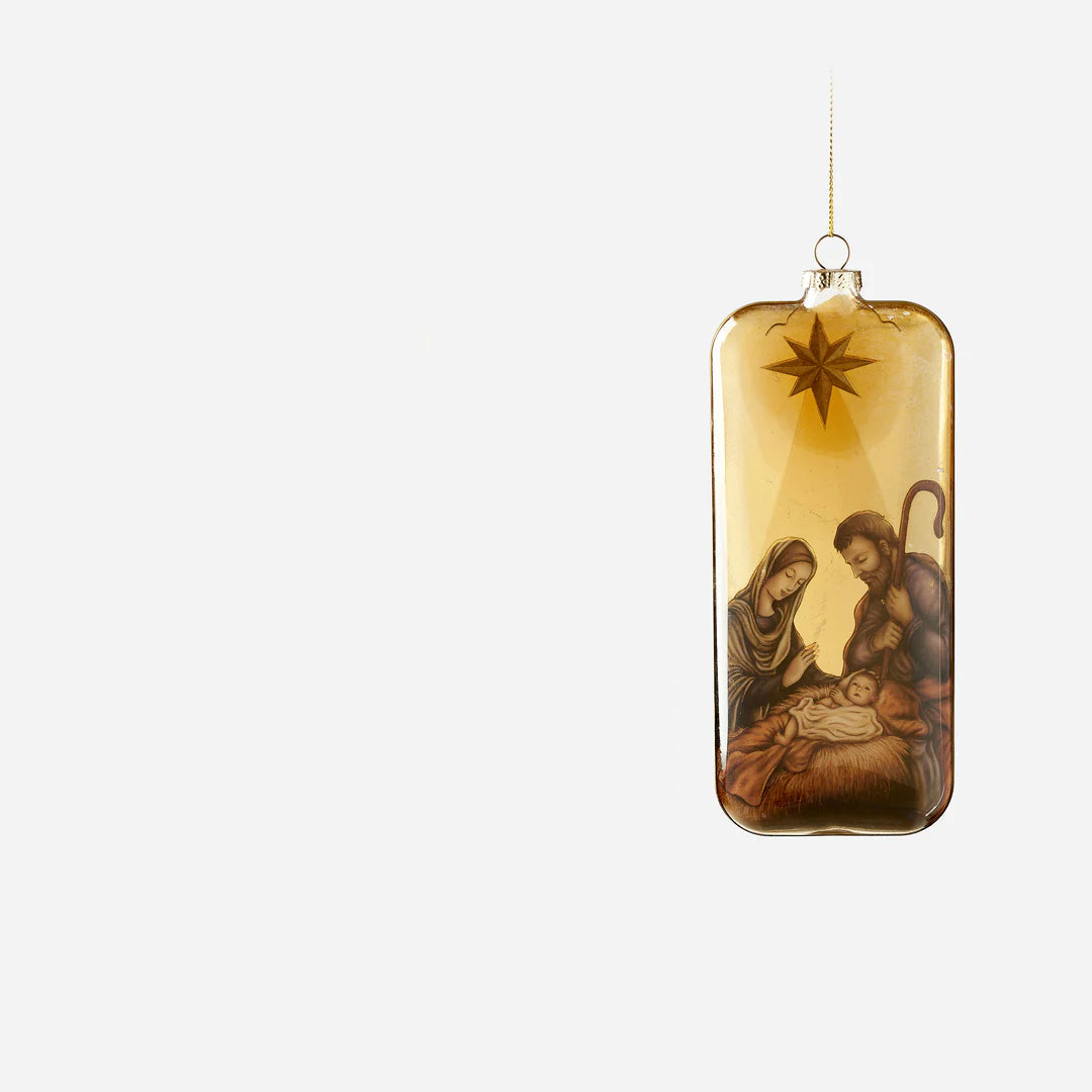 holy family ornament woth image of baby jesus in manger and mary and joseph gazing upon him with a star above
