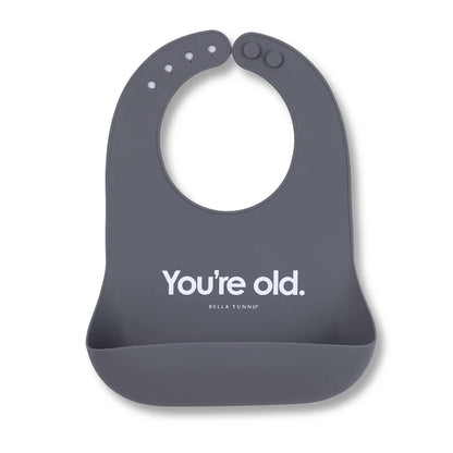 grey silicone bib with "you're old" printed in white on it
