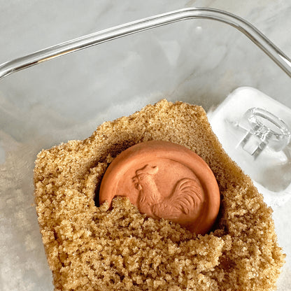Brown sugar with a terracotta disc in it in a glass container
