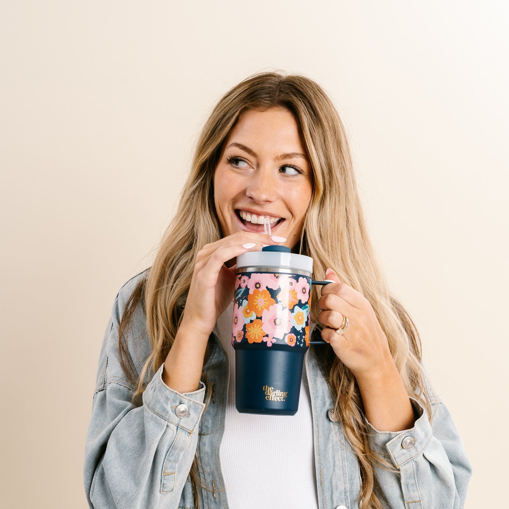 person smiling and sipping from Bright + Bloomy Mini On-The-Go Tumbler.