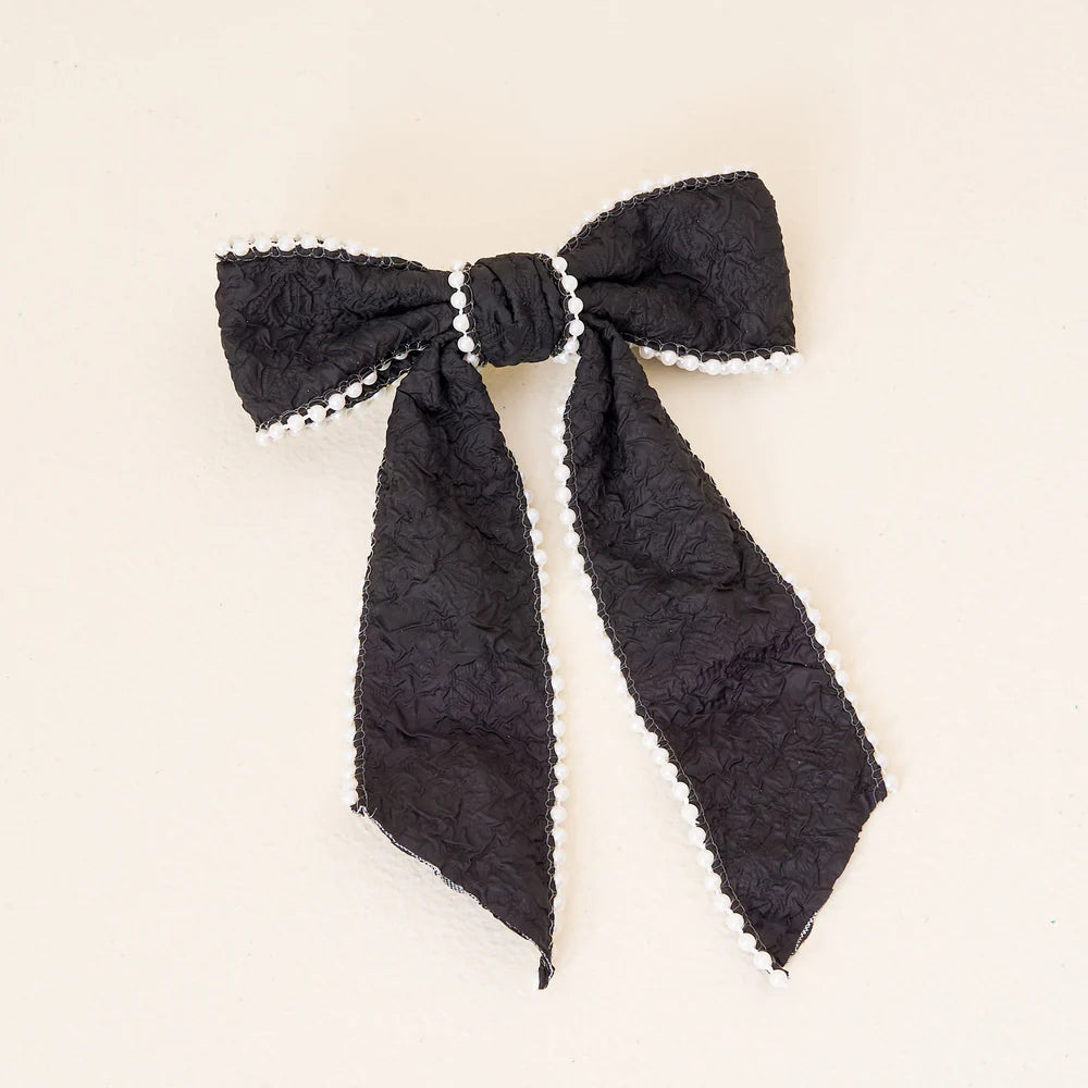 black pearl bow on an off-white backgorund.