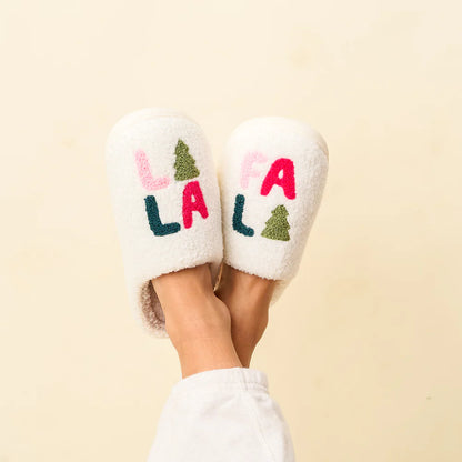 feet crossed in the air wearing fa la la fuzzy slippers.