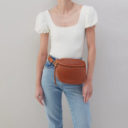 personw wearing jeans and a white top with wheat juno bag around their waist.