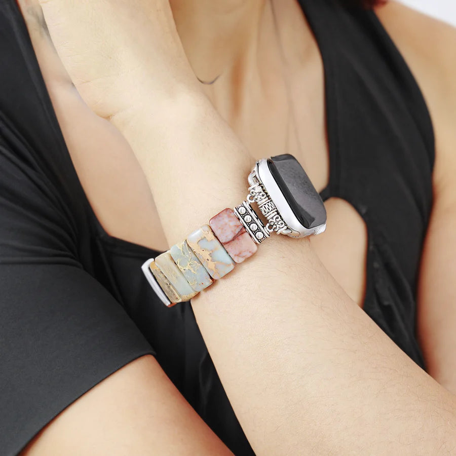 close-up of person's wrist wearing a tibetan jasper stretch watch strap on a white background.