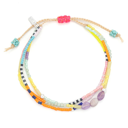 beaded bracelets in a rainbow of hues hues shown on a white background
