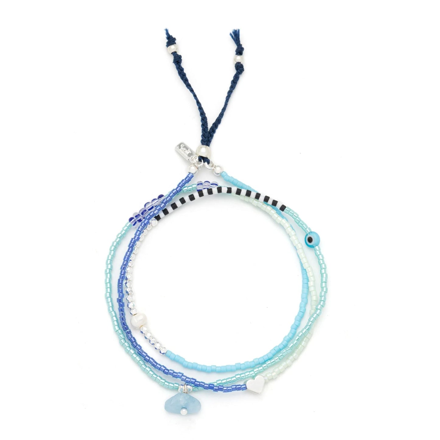 beaded wrap in hues of blues and white shown laying as a triple layered bracelet on a white background
