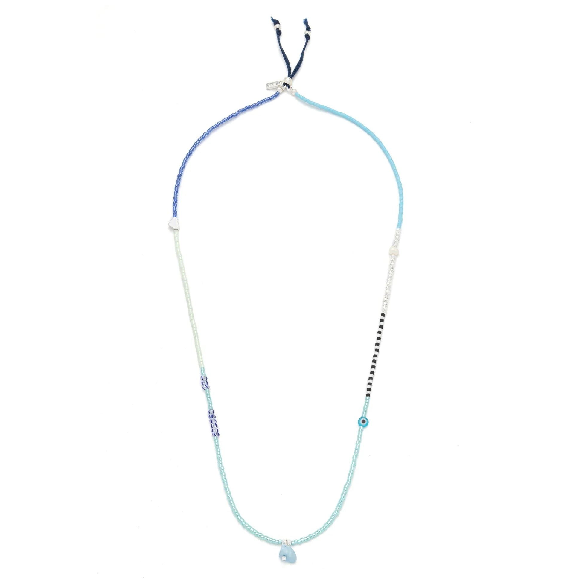 beaded wrap in  hues of blues and white shown laying as a necklace on a white background
