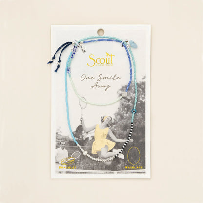 beaded wrap in dreamy hues of blues and white with accent beads on its card packaging
