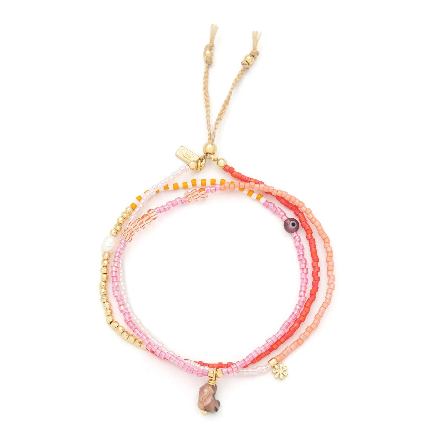 beaded wrap in pink and gold hues shown laying as a triple layered bracelet on a white background
