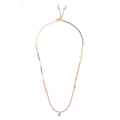 beaded wrap in pink, green, and gold hues shown laying as a necklace on a white background
