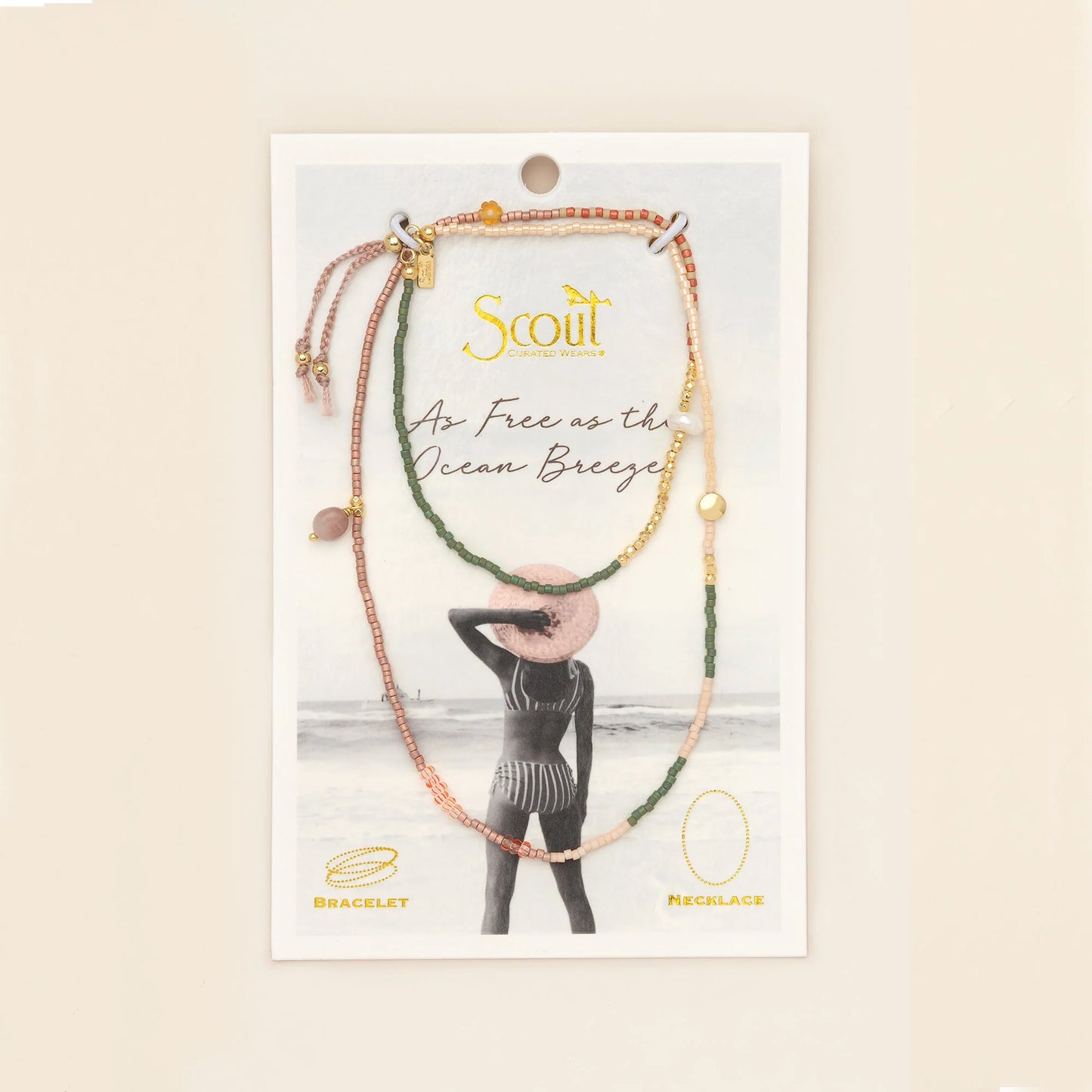 beaded wrap in pink, green, and gold hues with accent beads on its card packaging
