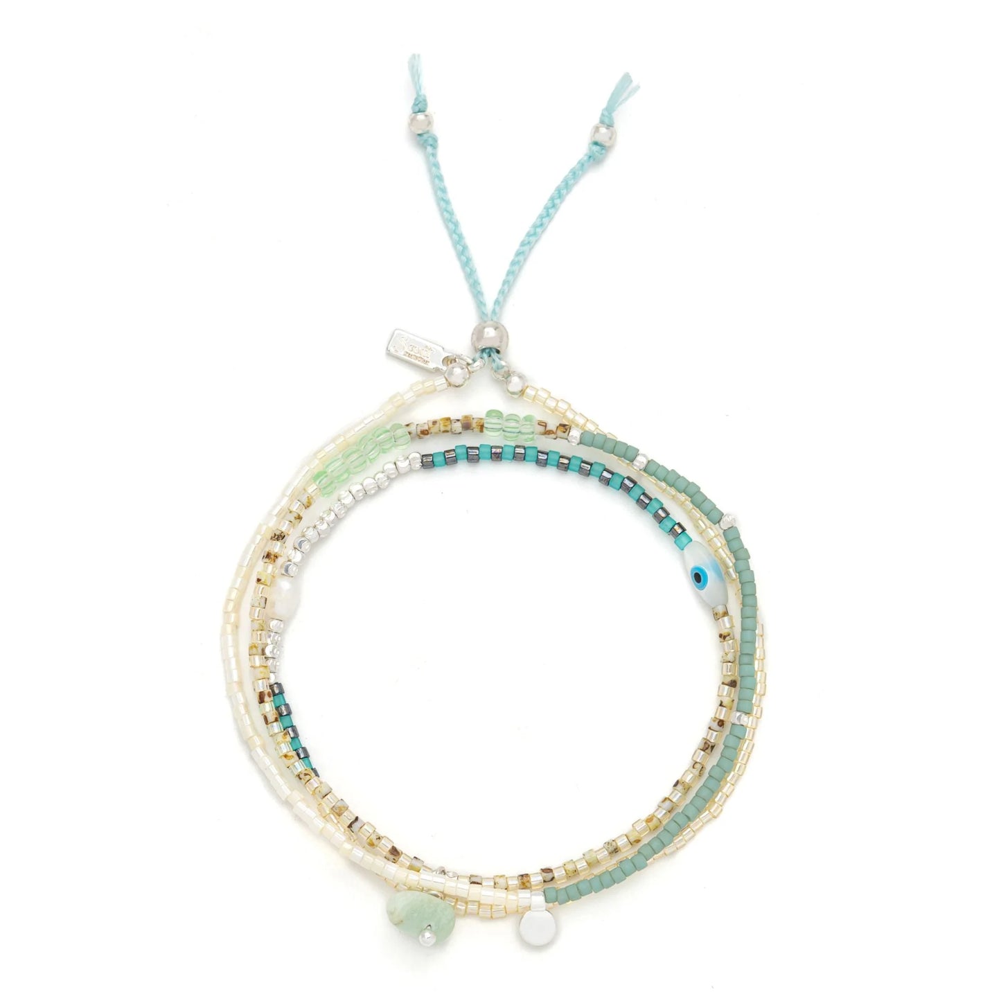 beaded wrap in dreamy green hues shown laying as a triple layered bracelet on a white background
