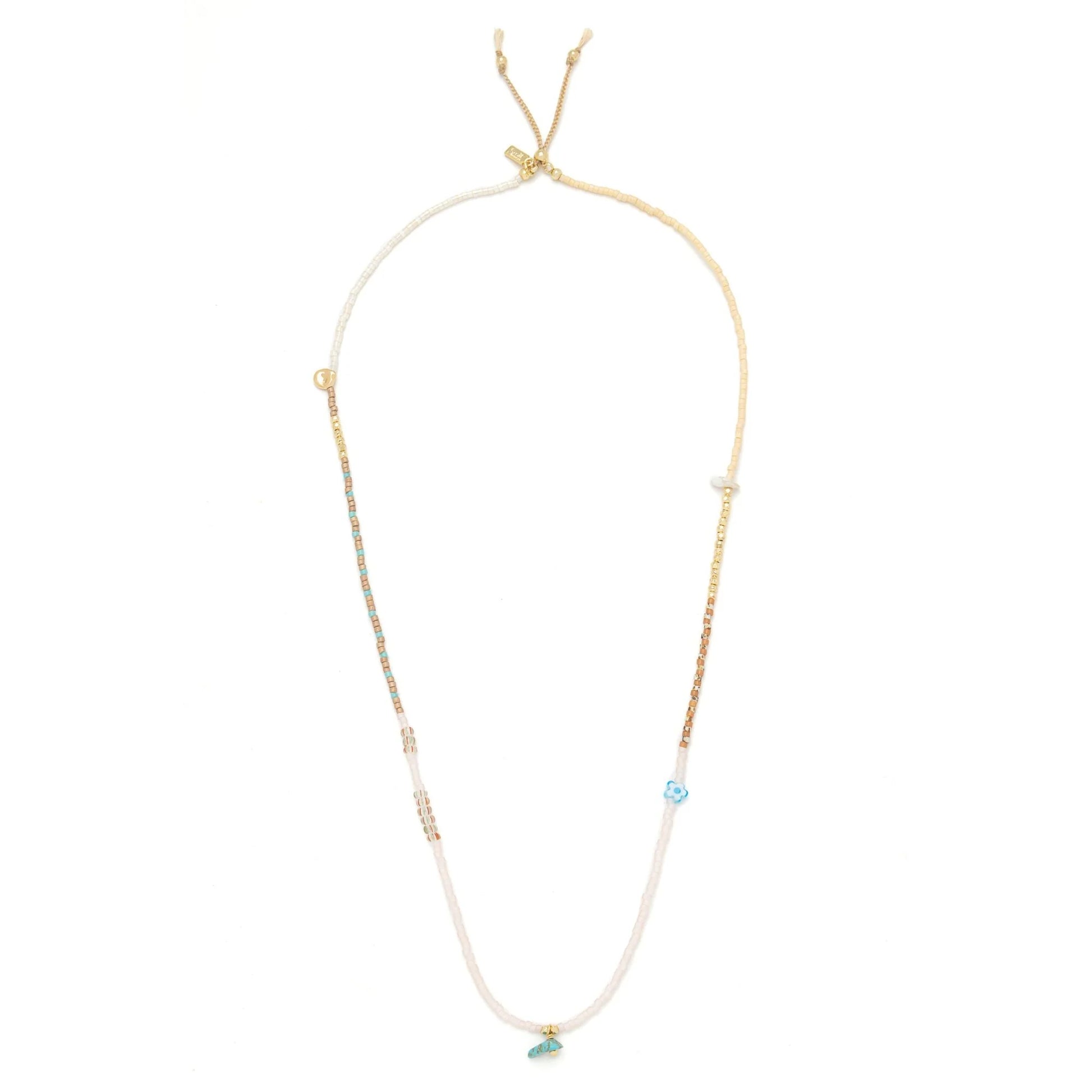 beaded wrap in blush pink and gold hues shown laying as a necklace on a white background

