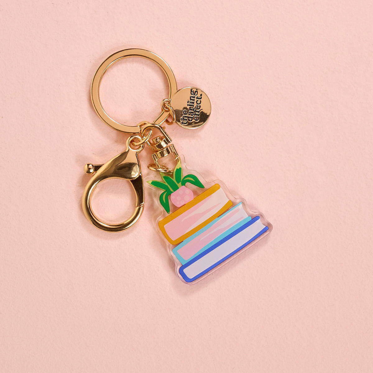 Acrylic book Nook keychain on a pink background