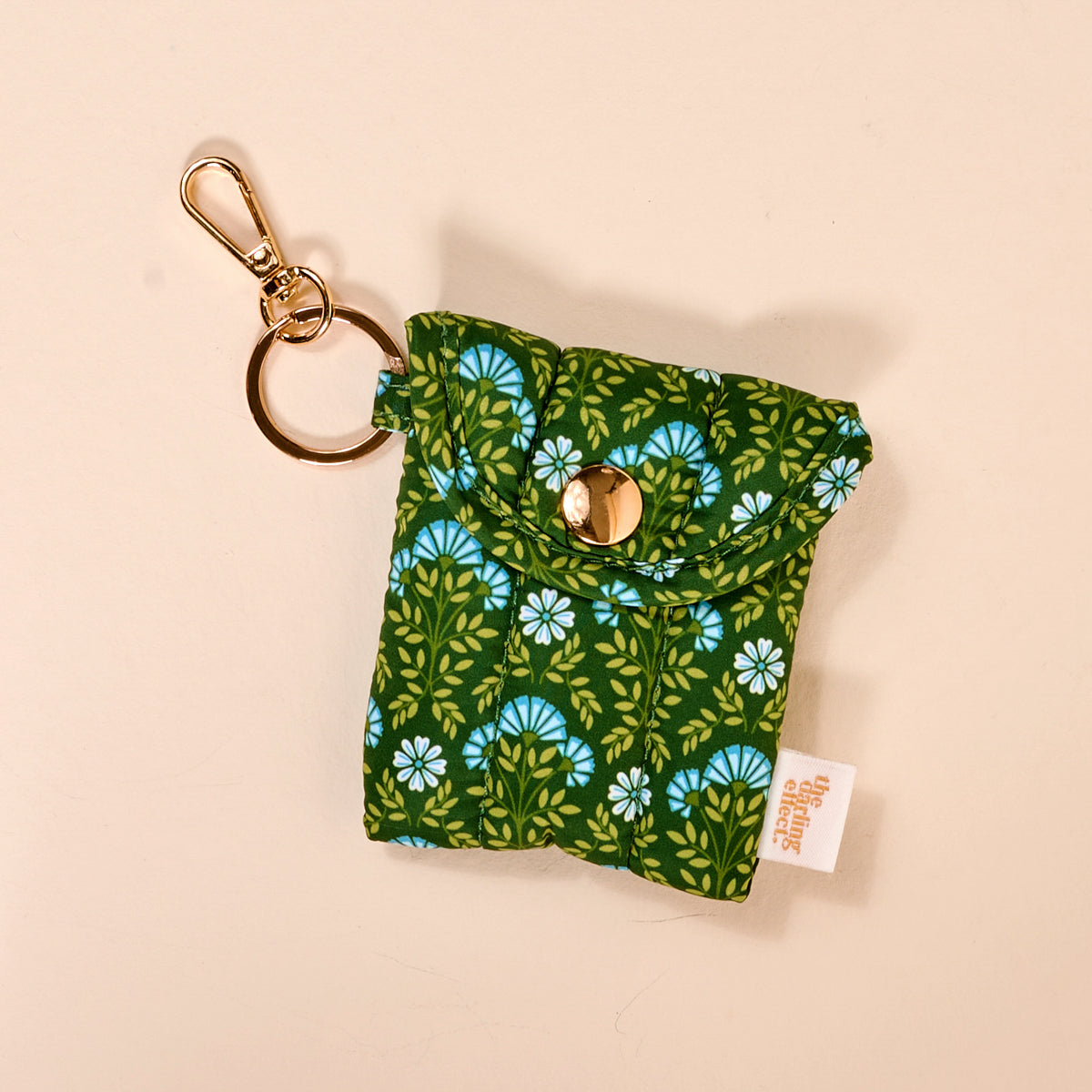 the Puffy Earbud Case in pattern Everbloom Forest Green on a beige background
