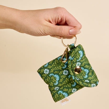 a person holding the Puffy Earbud Case in pattern Everbloom Forest Green