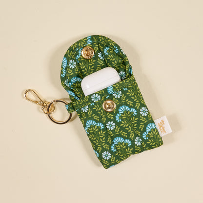 the Puffy Earbud Case in pattern Everbloom Forest Green with earbuds in them