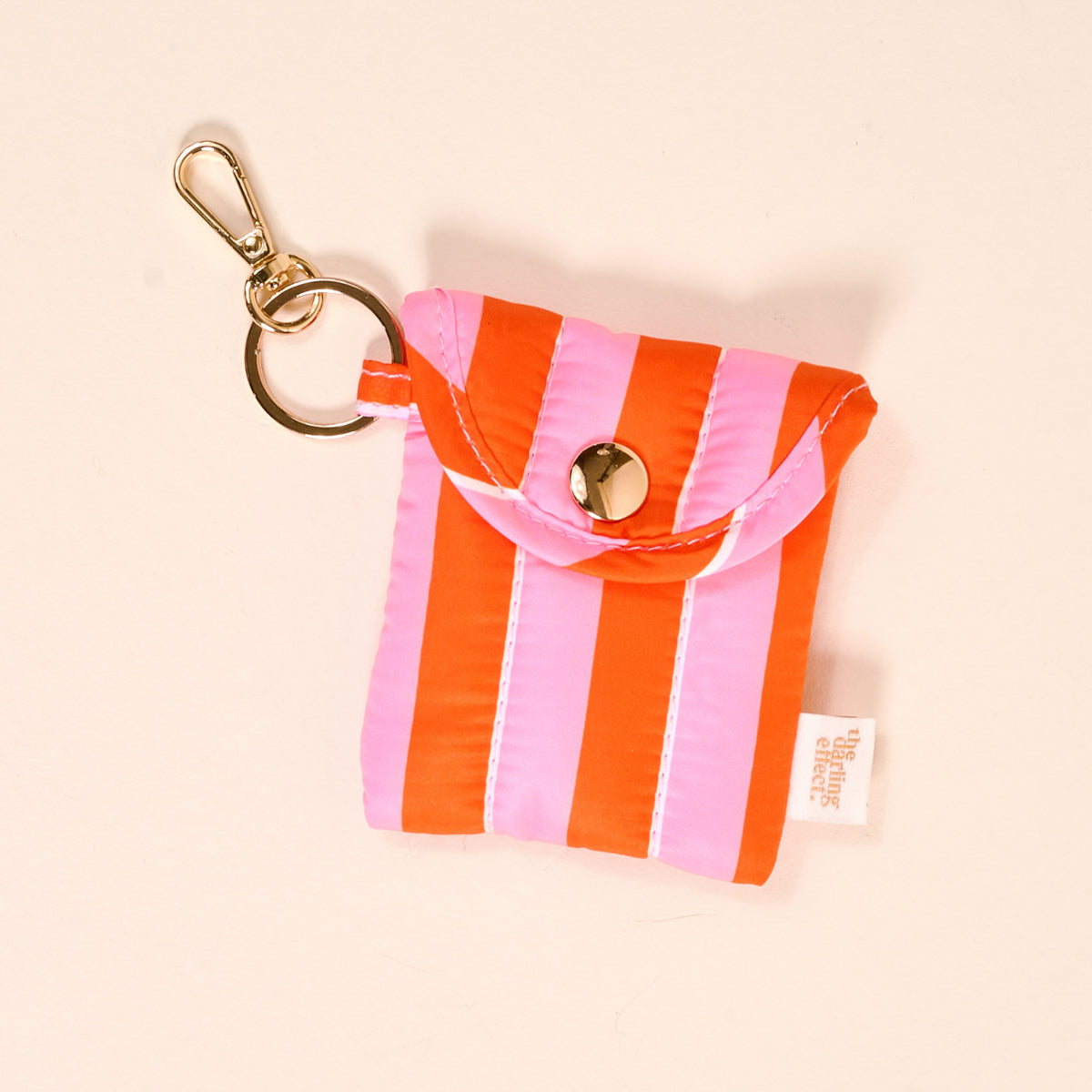 the Puffy Earbud Case in Sicily Stripes Pink on a beige background
