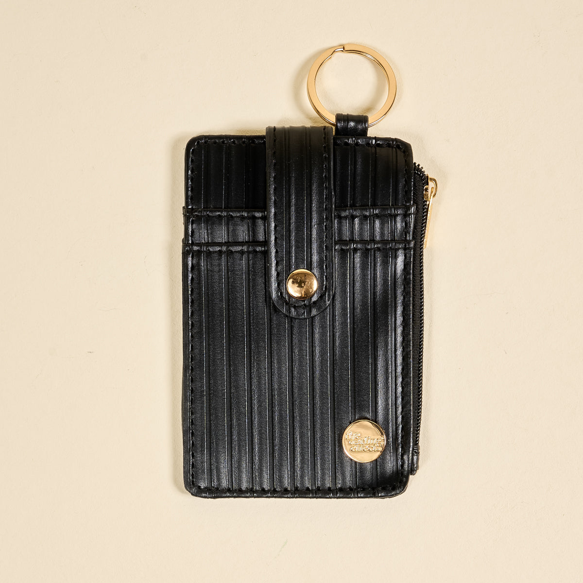 the Ripple Ridge Keychain Wallet in Black on a beige background