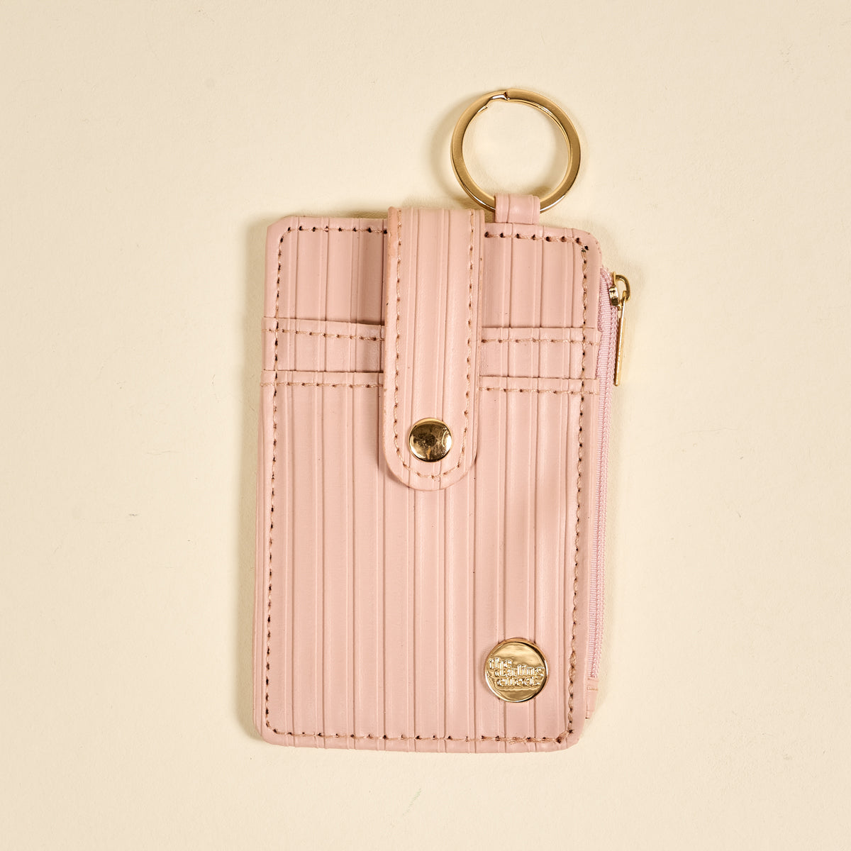 the Ripple Ridge Keychain Wallet in Blush on a beige background
