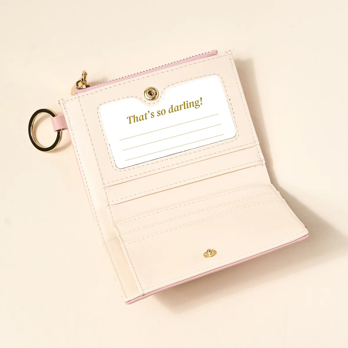 blush colored luxe pocket wallet opened up on a beige background
