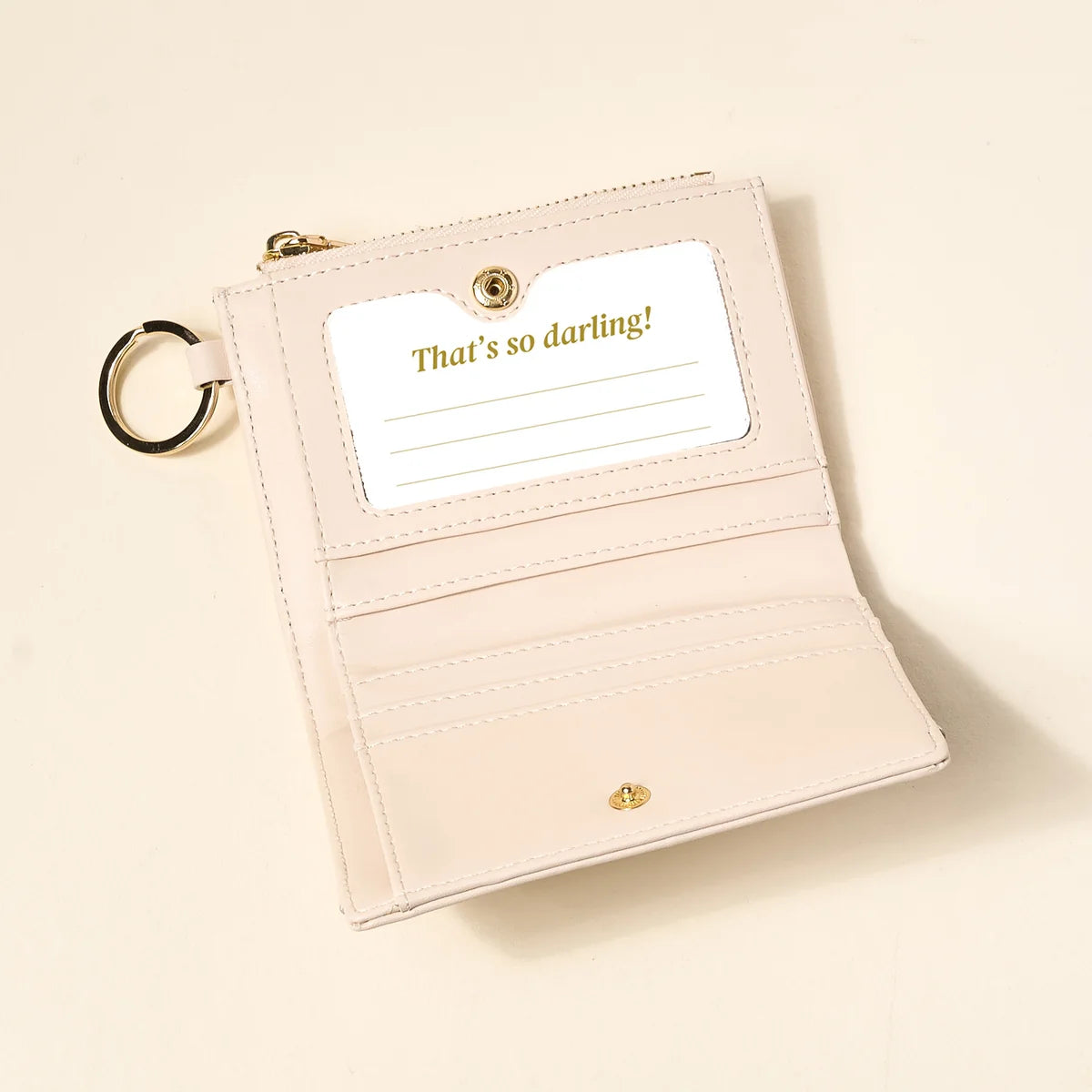 oat colored luxe pocket wallet opened up on a beige background