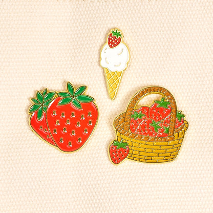 Set of strawberry-themed pins including a basket, ice cream cone, and strawberries on a beige background.