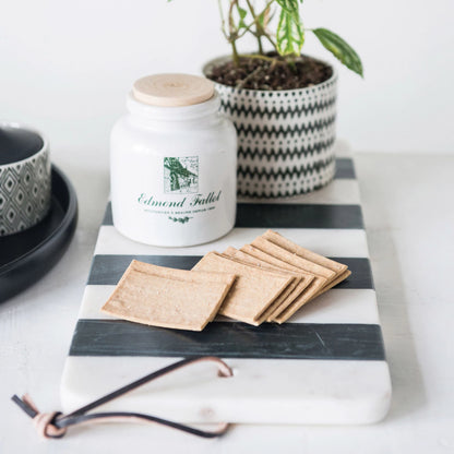 striped marble board with a plant and decor items on it set on a table.