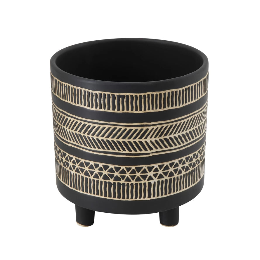 round black footed planter with cream colored geometric bands all around the perimeter.