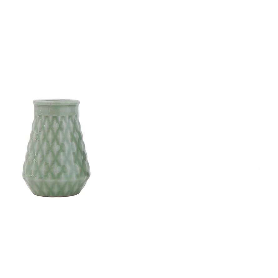 small jade green vase with diamond pattern on a white background