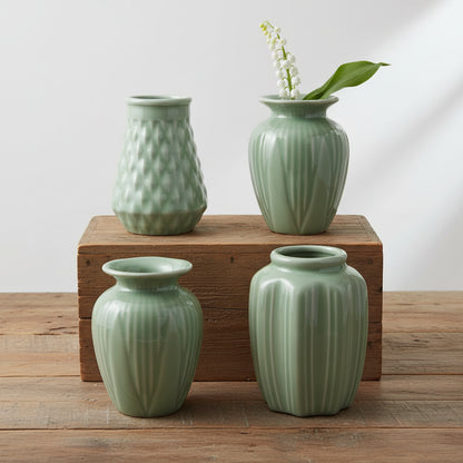 4 assorted jade green vases arranged on a wooden surface