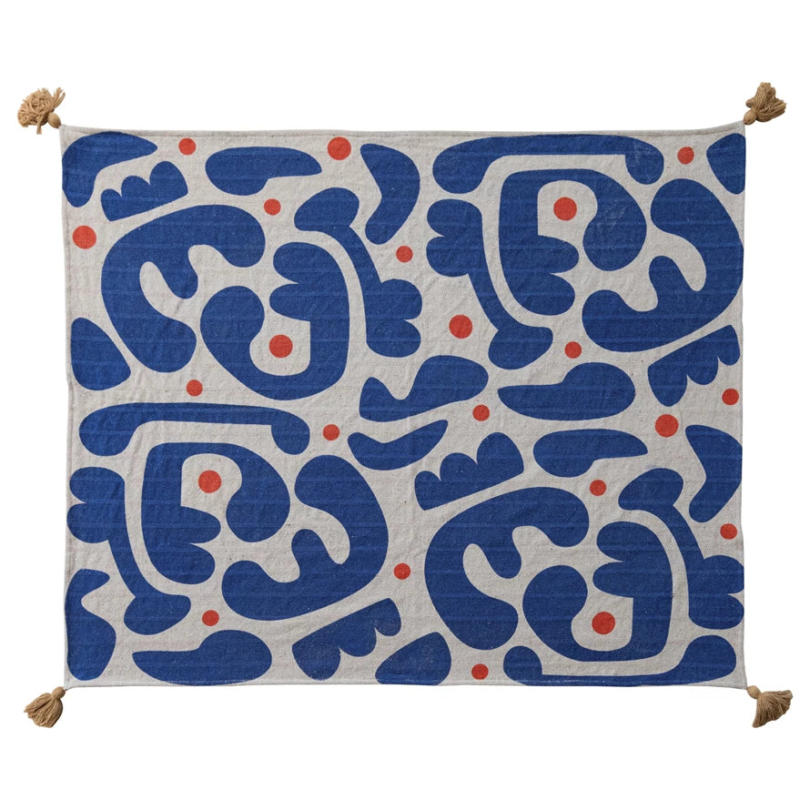 Decorative blanket with blue and orange pattern laying flat on a white background