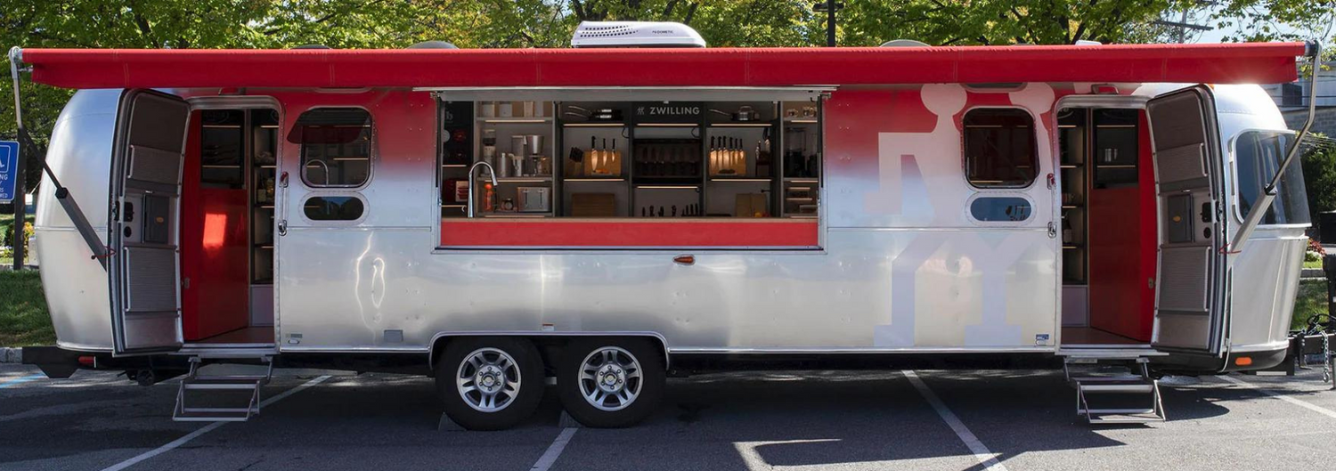 Zwilling Airstream trailer parked at an event, with window open and ready to serve customers