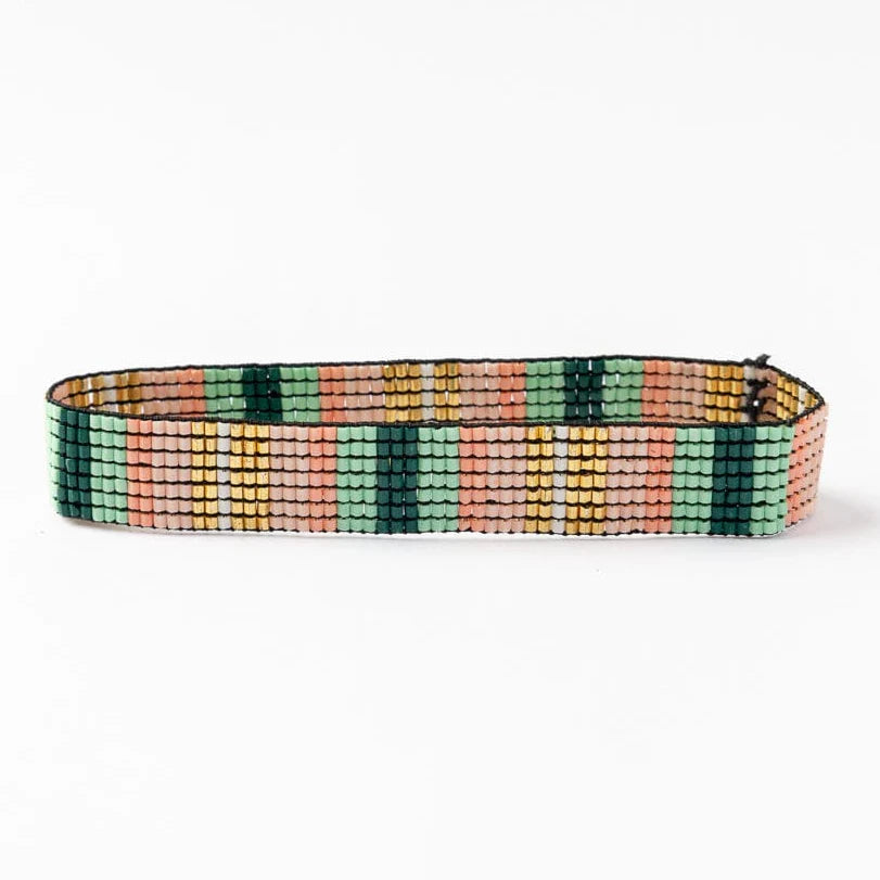 green, blush, and gold beaded bracelet on a white background