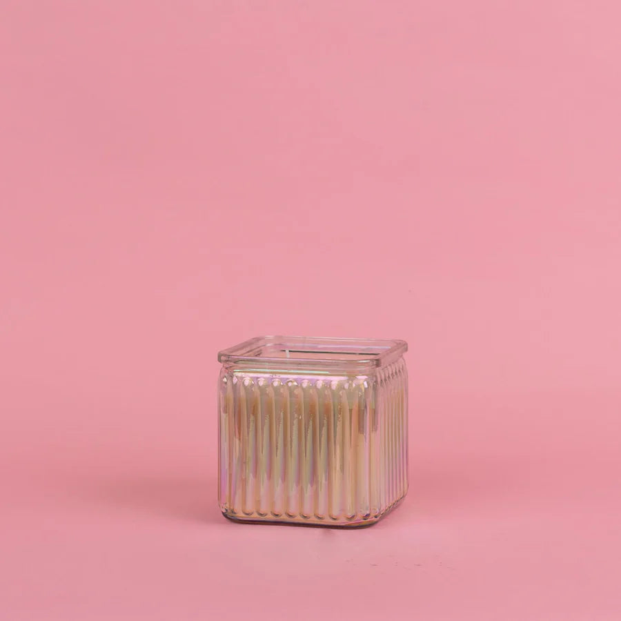 Square glass container of sweet grace candle on a pink background