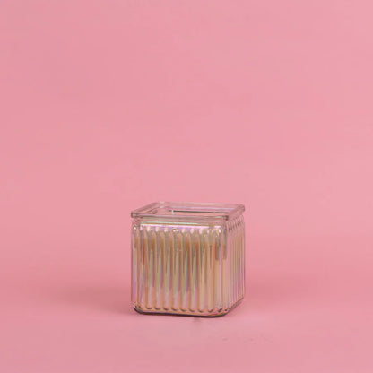 Square glass container of sweet grace candle on a pink background