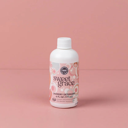 bottle of sweet grace laundry detergent shown on a pink background