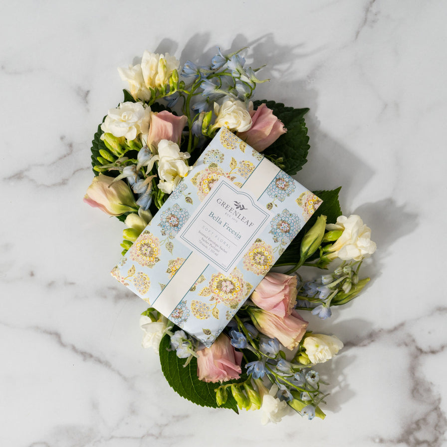 Bella Freesia Large Sachet set among cut florals laying on a marble counter.