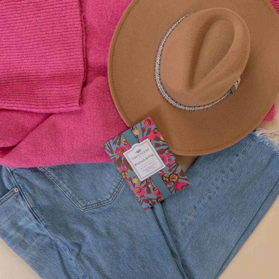 Rhubarb & Oak Large Sachet arranged with jeans, a pink sweater, and a cowgirl hat.