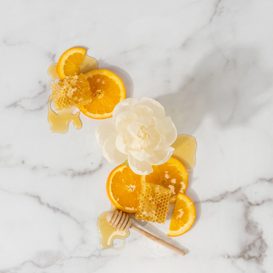 top view of Orange & Honey Flower Diffuser on a marble counter arranged with orange slices and honey.