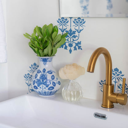 Classic Linen Flower Diffuser set on a bathroom counter next to the faucet and a vase of greenery.