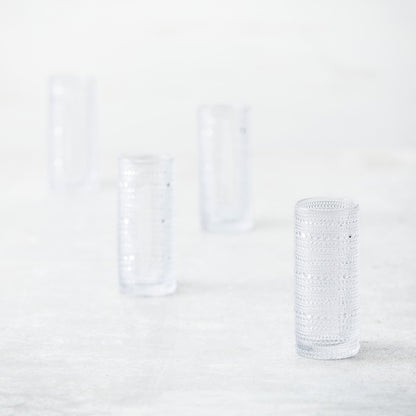 4 clear jupiter collins glasses arranged on a countertop.