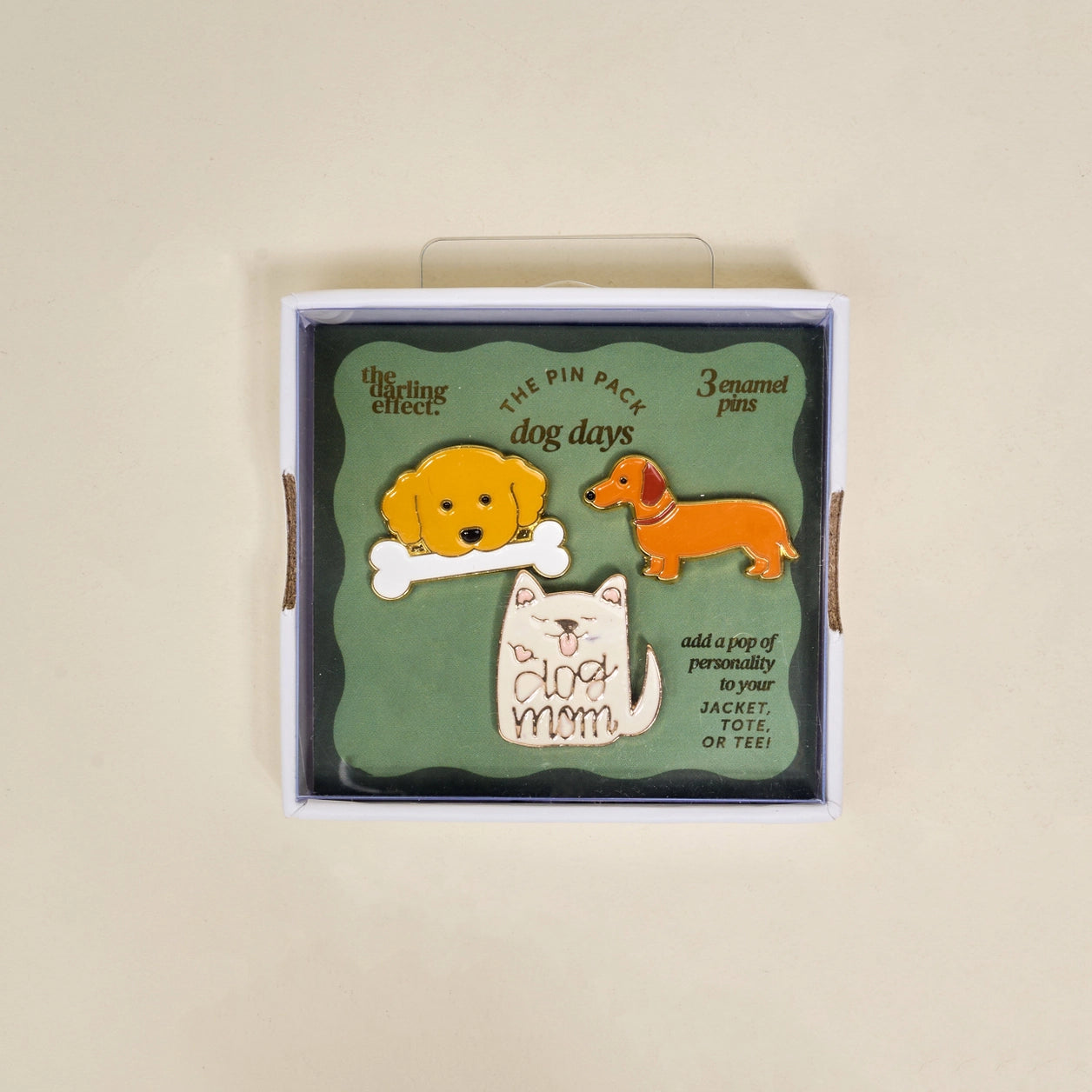 Box of 'Dog Days' pin pack with dog  designs in box packaging on a beige background