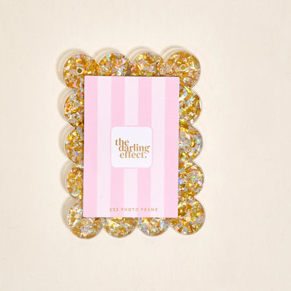 Scalloped gold confetti magnetic frame on a white background.