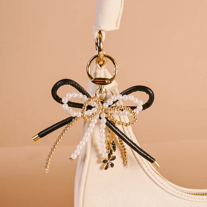 luxe glam cherry bliss Layered Bows Bag Charm hung on a white purse