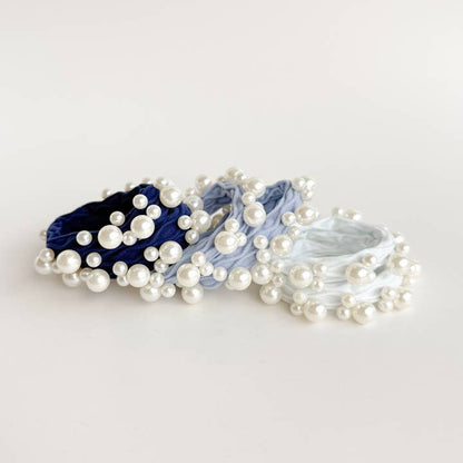 6 hair ties in blue and white with pearls on them in a row