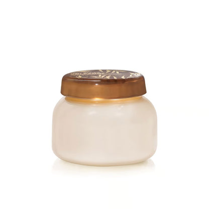 creamy white volcano signature candle jar with brown lid shown on a white background