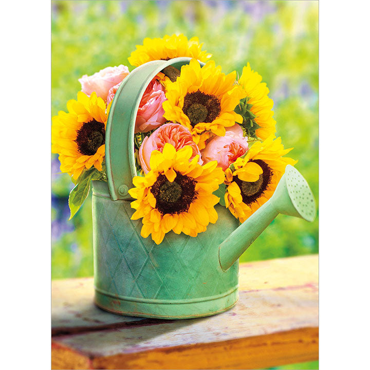 front of card is a bouquet of flowers inside a green watering can