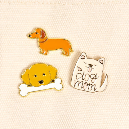 Three dog-themed pins on a beige background
