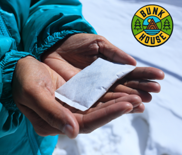 hands holding a Cabin Fever Hand Warmer while standing in the snow